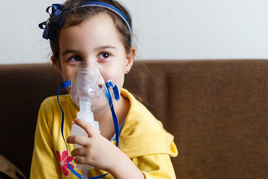 Little girl making inhalation with nebulizer at home child asthma inhaler inhalation nebulizer